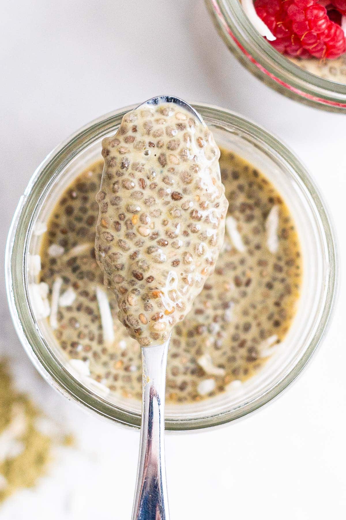 Close up of chia pudding on a spoon above the jar.