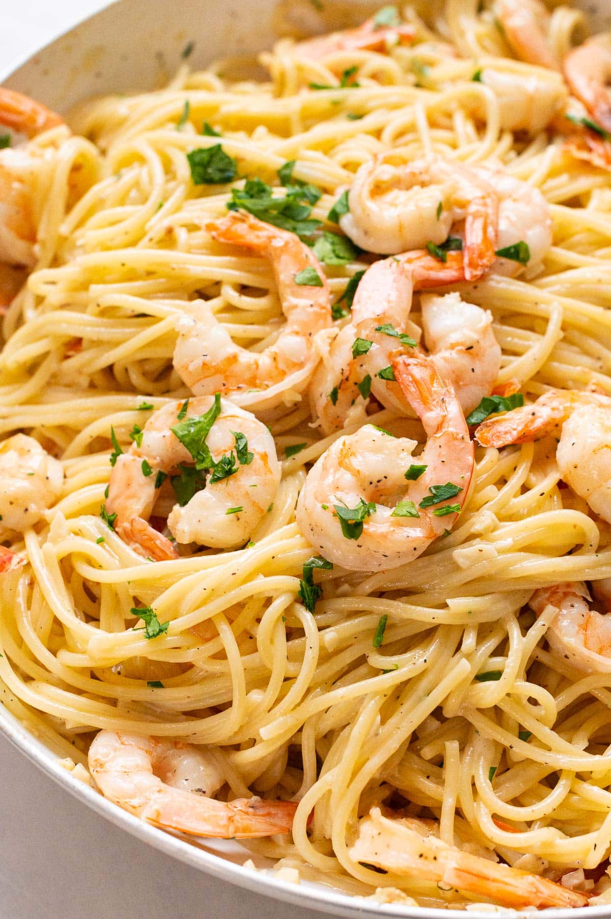Close up of garlic butter shrimp pasta garnished with parsley.