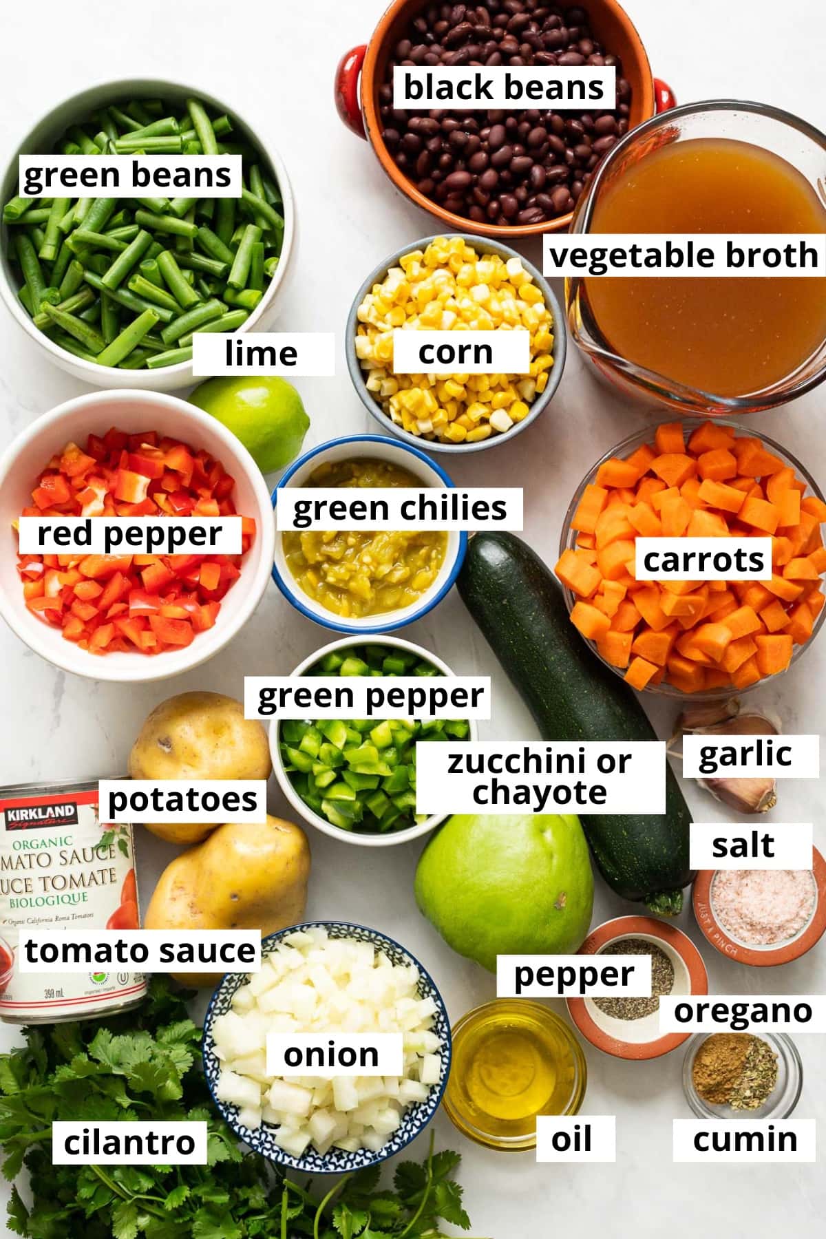 Green beans, black beans, broth, corn, lime, bell peppers, green chilies, carrots, zucchini, potatoes, tomato sauce, onion, cilantro, oil, garlic and spices.