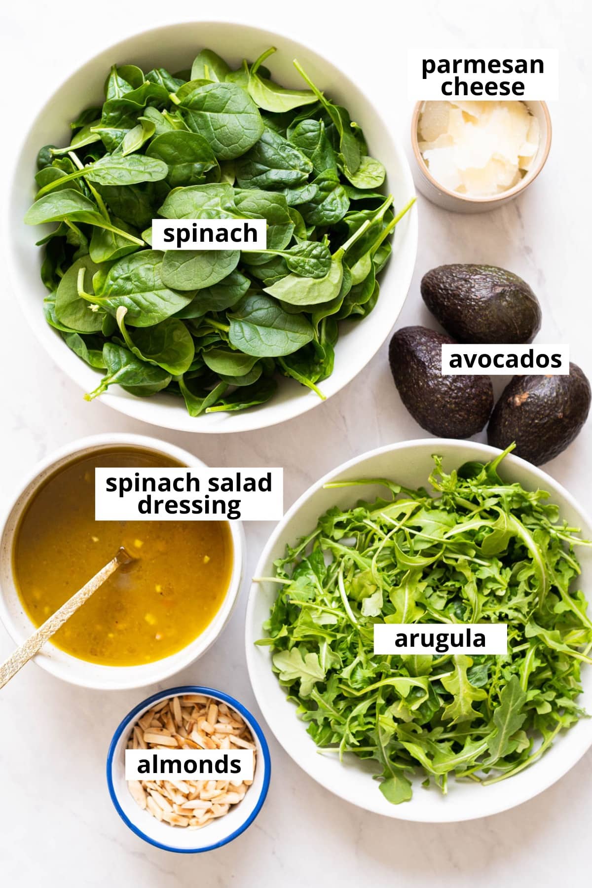 Spinach, arugula, avocados, spinach salad dressing, parmesan cheese, almonds.