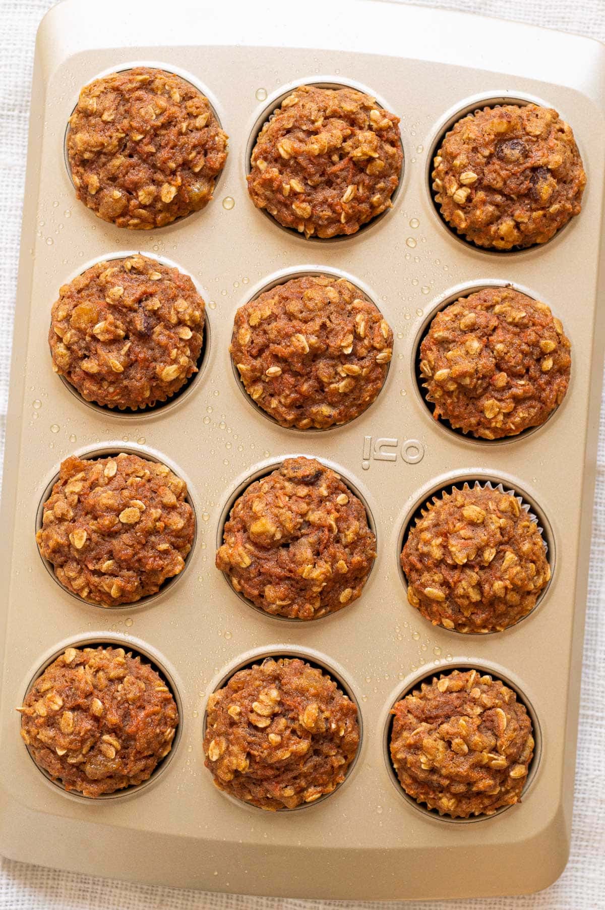 Healthy carrot muffins in golden baking pan.