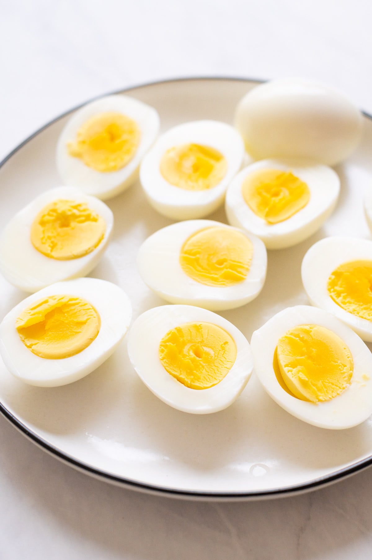 Sliced hard boiled eggs on white plate.