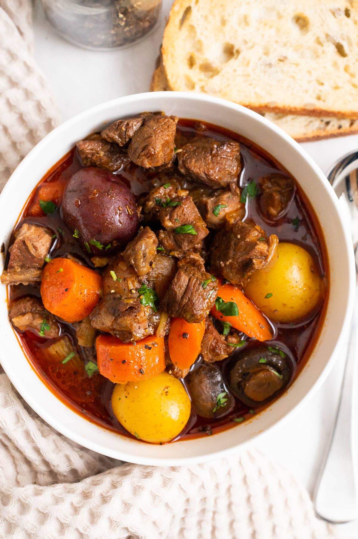 A bowl of lamb stew served with bread.