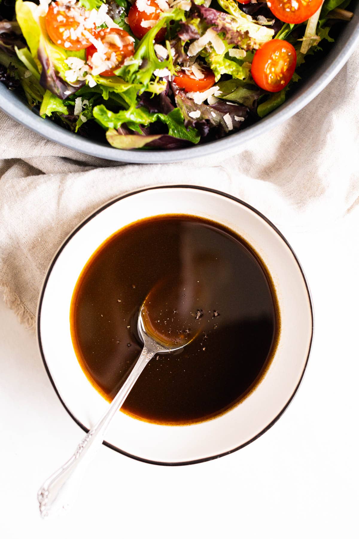 Balsamic vinaigrette in white bowl with a spoon.