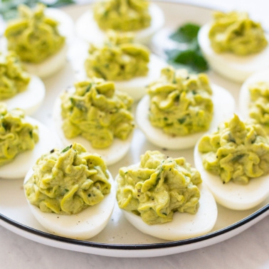 Side view of avocado deviled eggs on a plate.