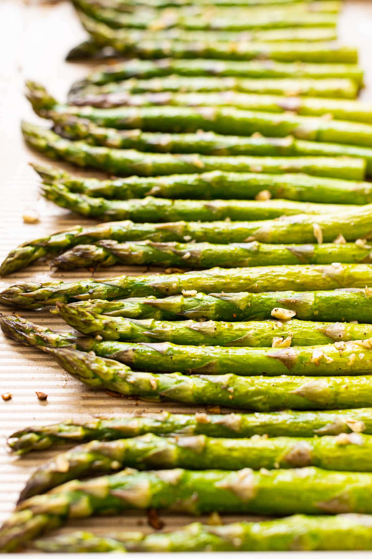 Oven baked asparagus with garlic on a baking sheet.