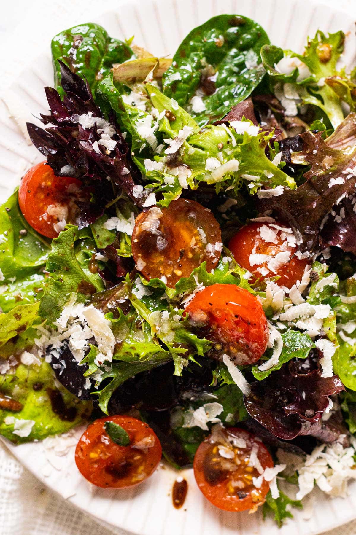 Simple salad with spring mix, cherry tomatoes, parmesan cheese and balsamic vinaigrette.