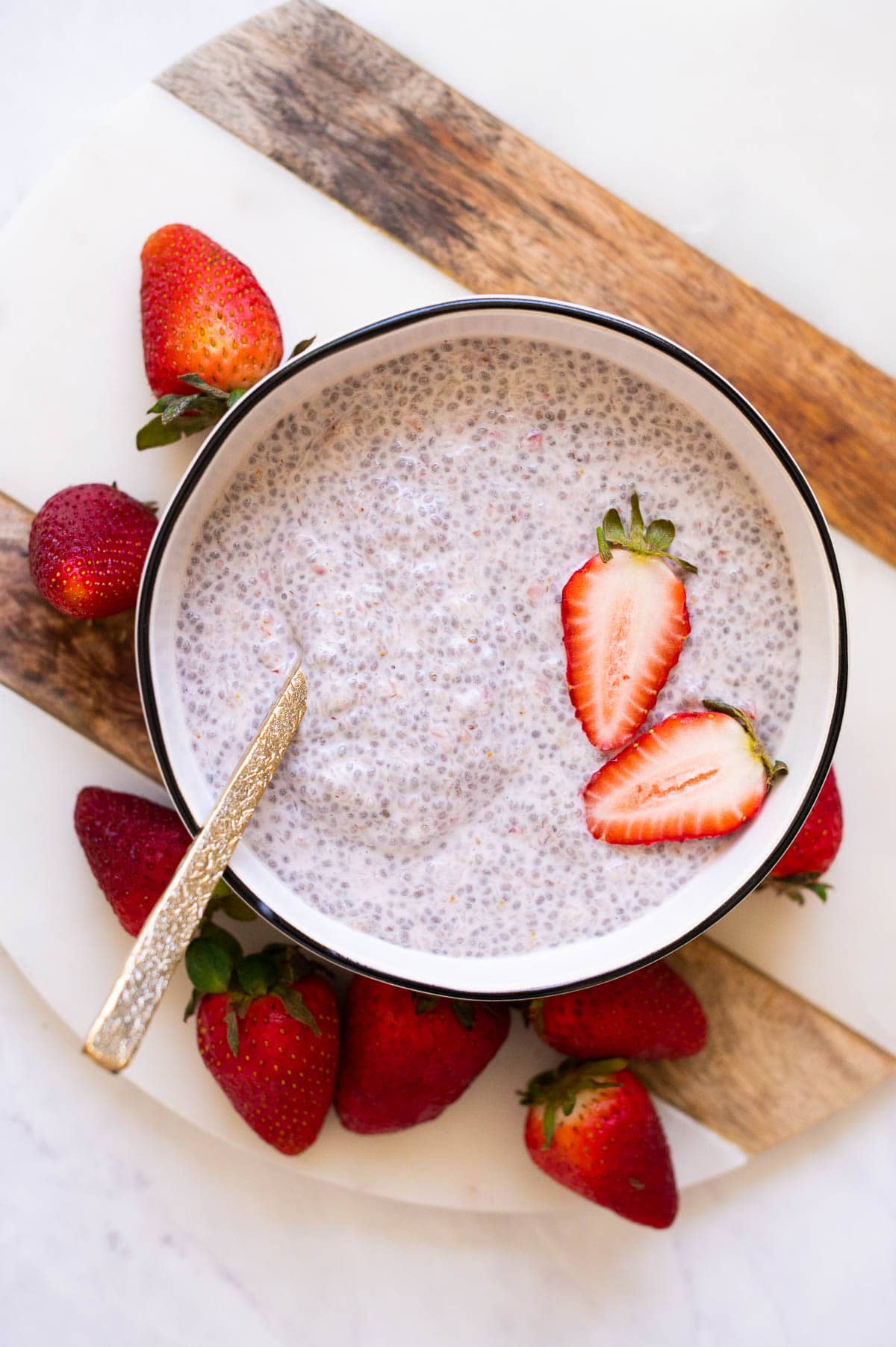 Chia seed pudding with strawberries served in a bowl with a spoon.