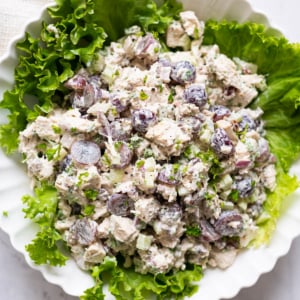 Classic chicken salad recipe served on a bed of lettuce leaves in a bowl.