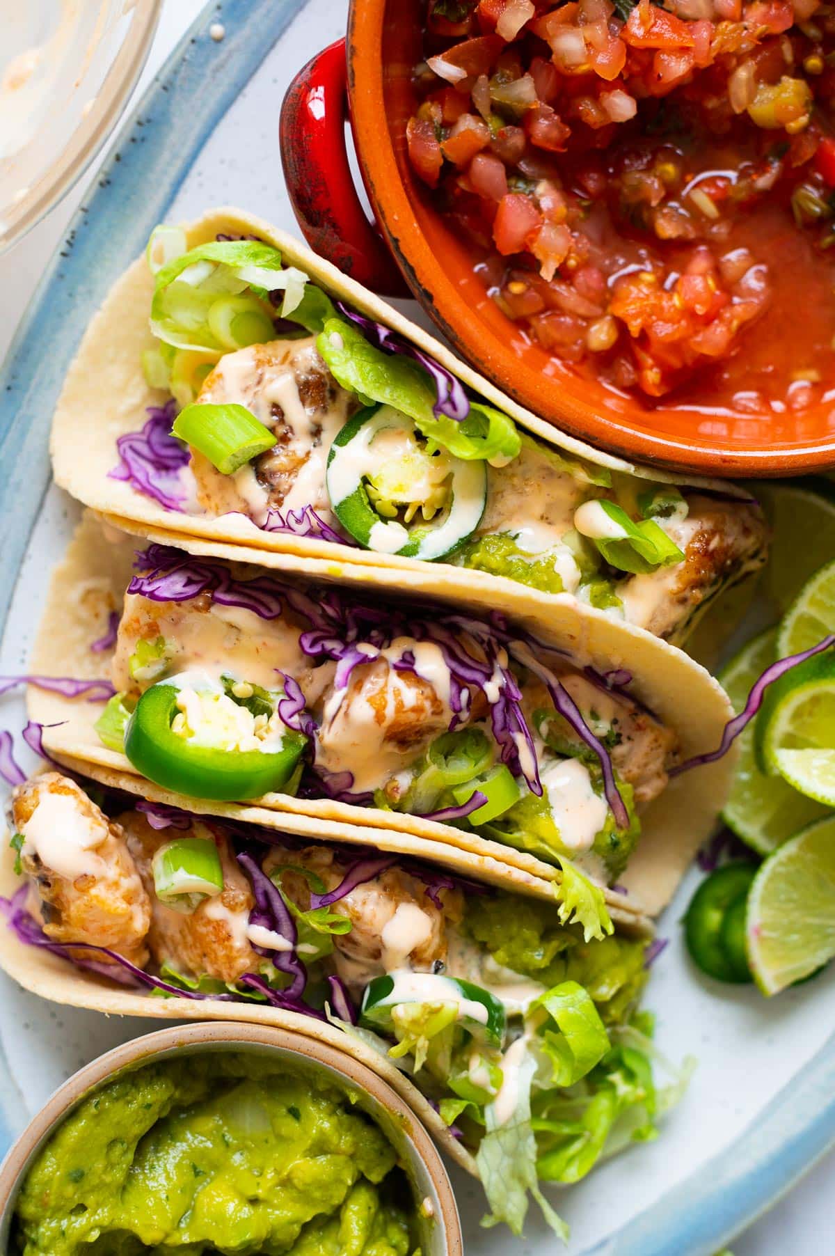 Bang bang shrimp tacos served with jalapeno, guacamole and pico de gallo.