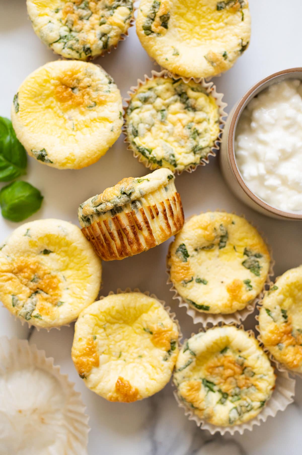 Egg bites with cottage cheese and basil in muffin liners.