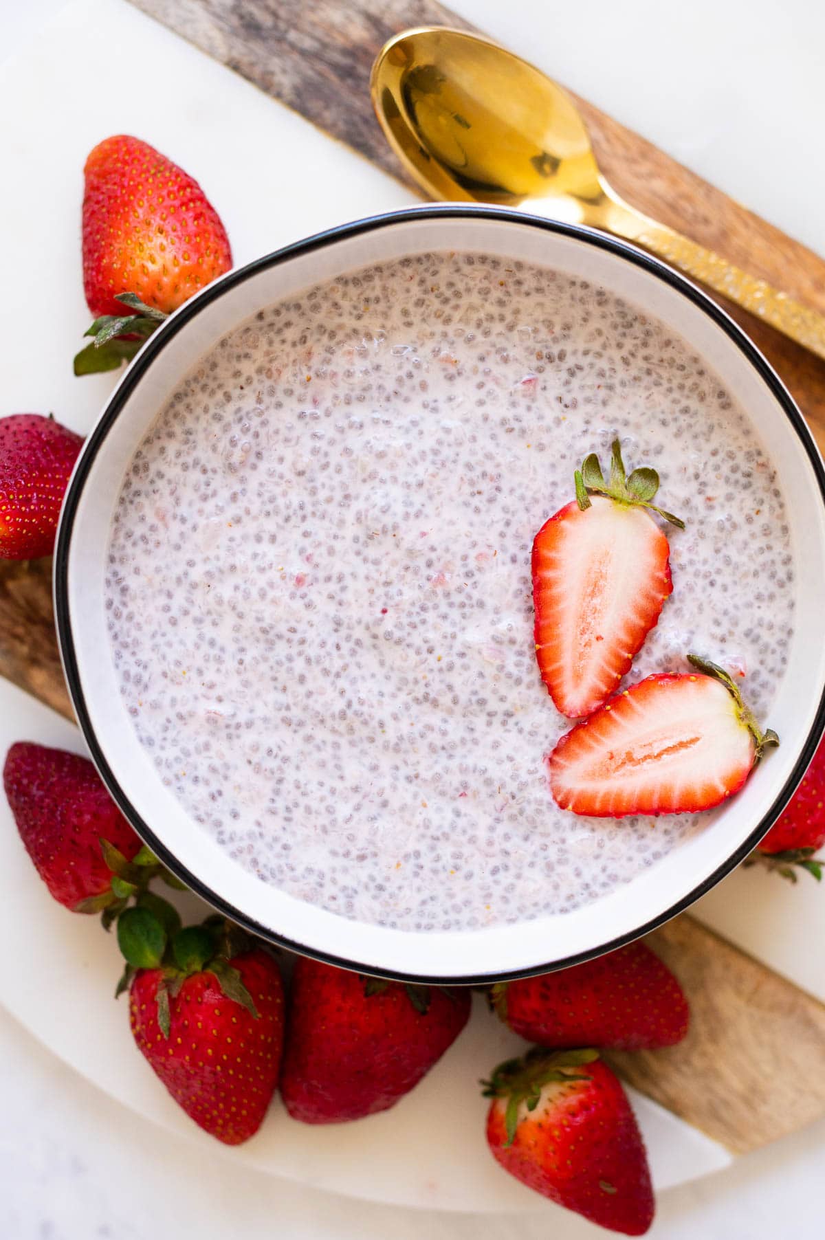 Strawberry chia seed pudding in a bowl garnished with fresh strawberries.