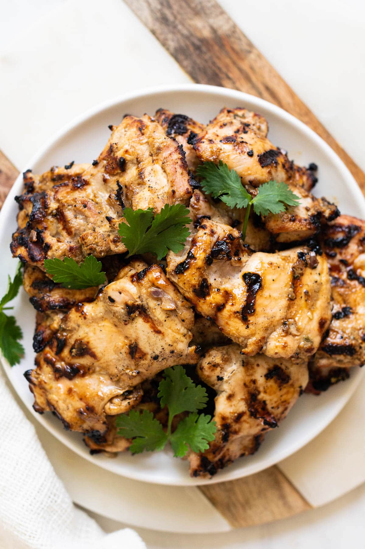 Grilled yogurt marinated chicken garnished with cilantro and served on a plate.