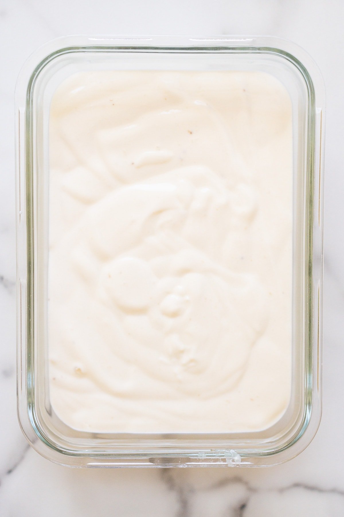 Banana cottage cheese ice cream in glass container before freezing.