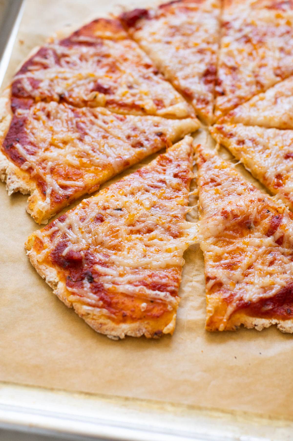 Cottage cheese pizza crust made with gluten free flour on parchment paper.