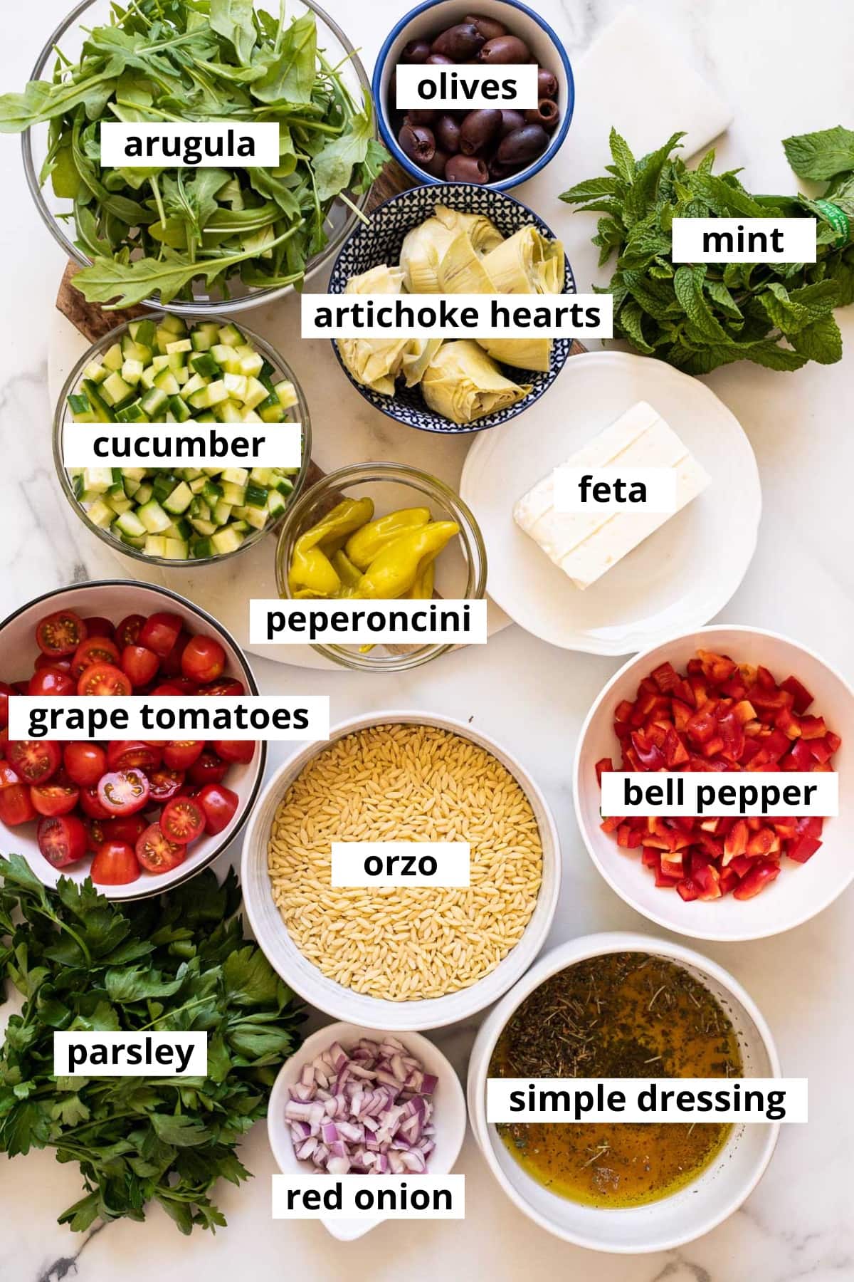 Arugula, artichoke hearts, olives, mint, cucumber, feta, peperoncini, grape tomatoes, orzo, bell pepper, parsley, red onion and salad dressing.