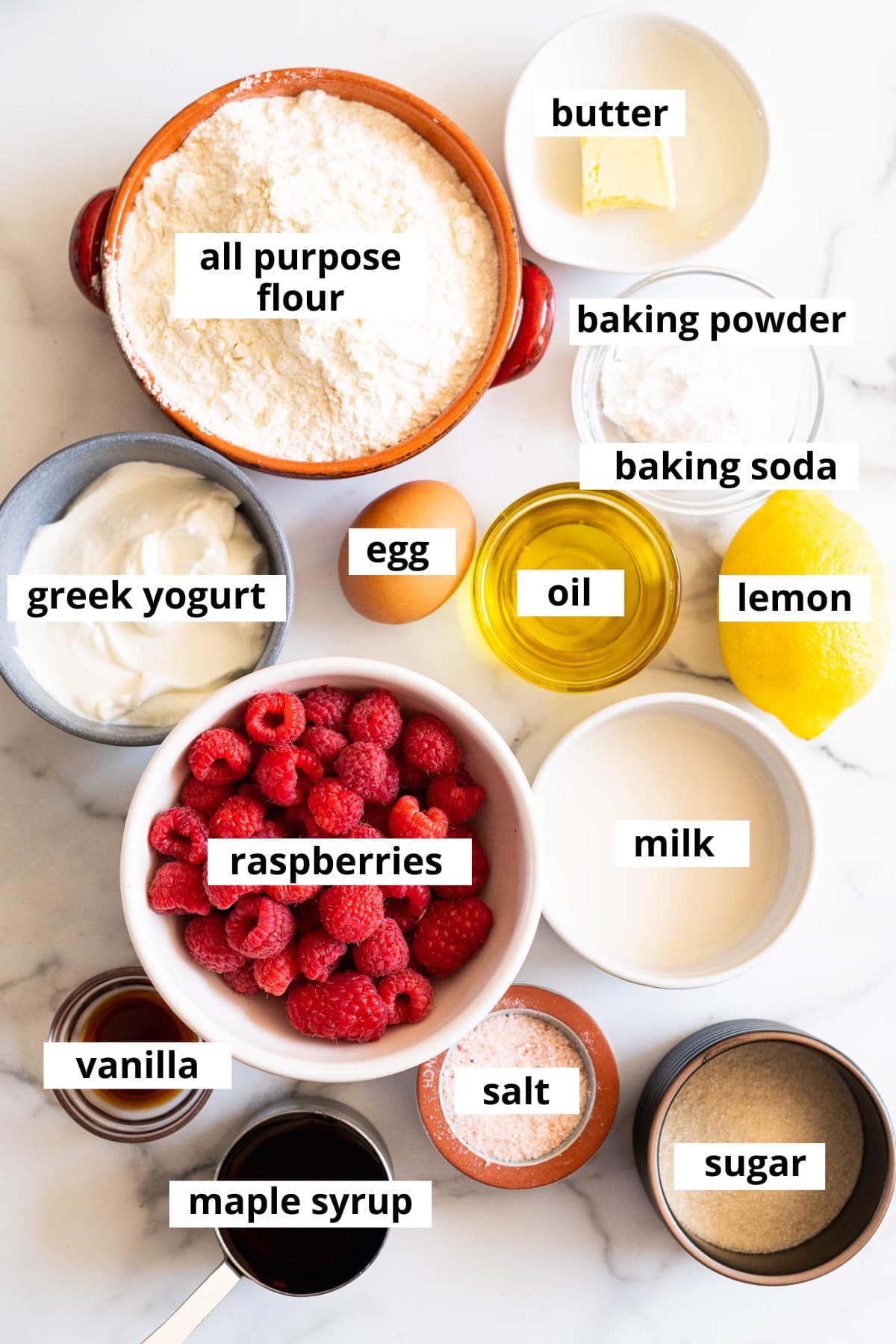 All purpose flour, butter, baking powder, baking soda, lemon, oil, egg, Greek yogurt, raspberries, milk, sugar, vanilla, maple syrup and salt.