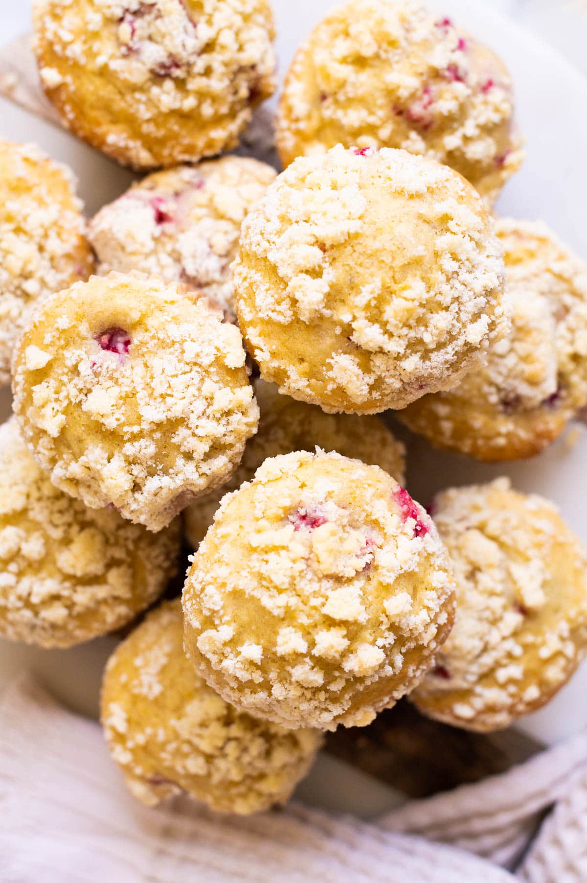 Raspberry muffins with streusel topping in a stack on a serving platter.