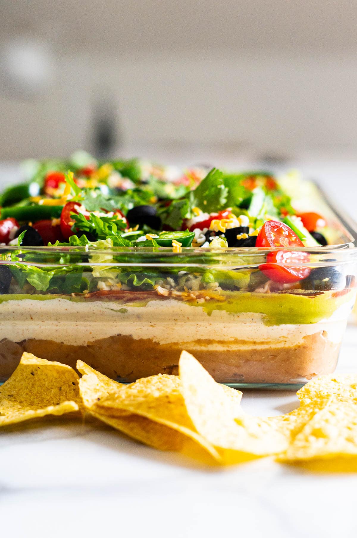Side view of 7 layer dip in a glass baking dish.