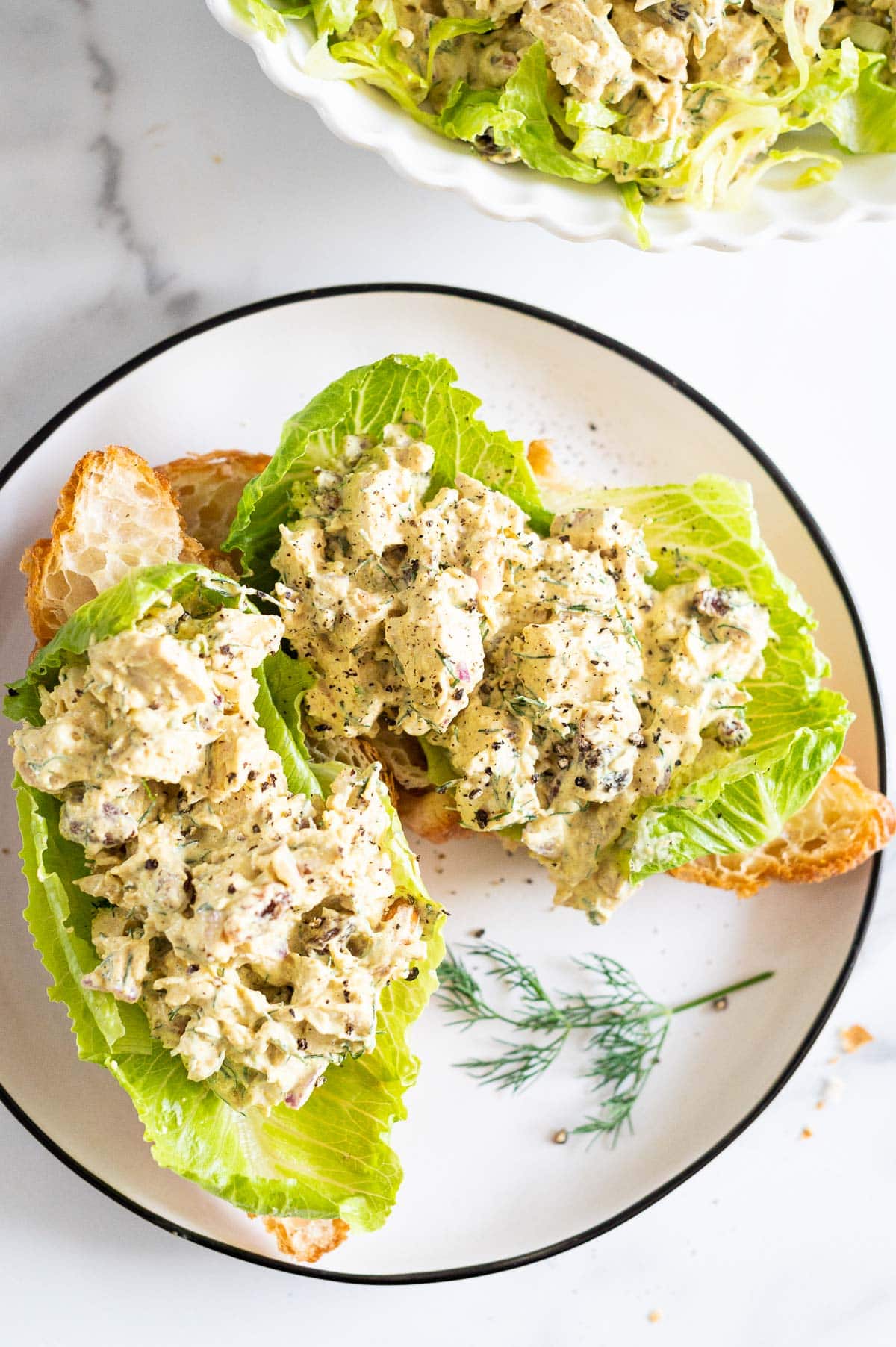 Curried chicken salad sandwich on a plate.