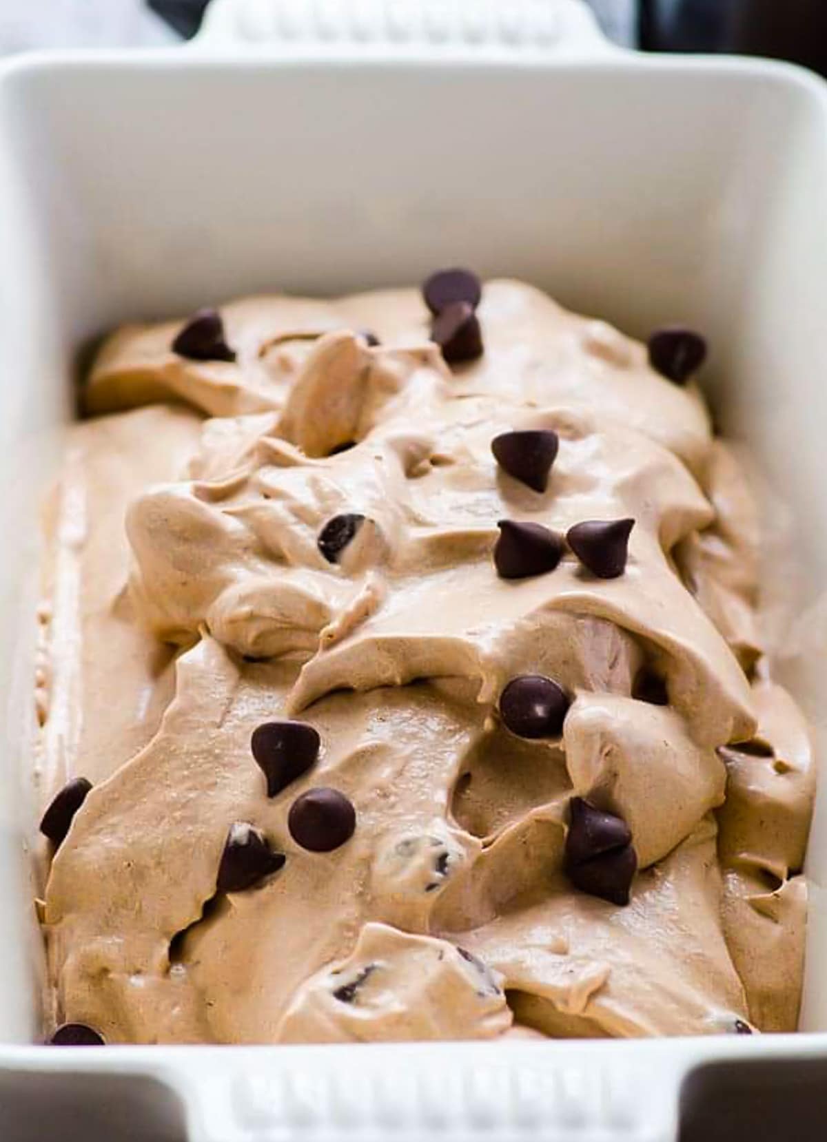 Healthy chocolate ice cream topped with chocolate chips in a ceramic dish.