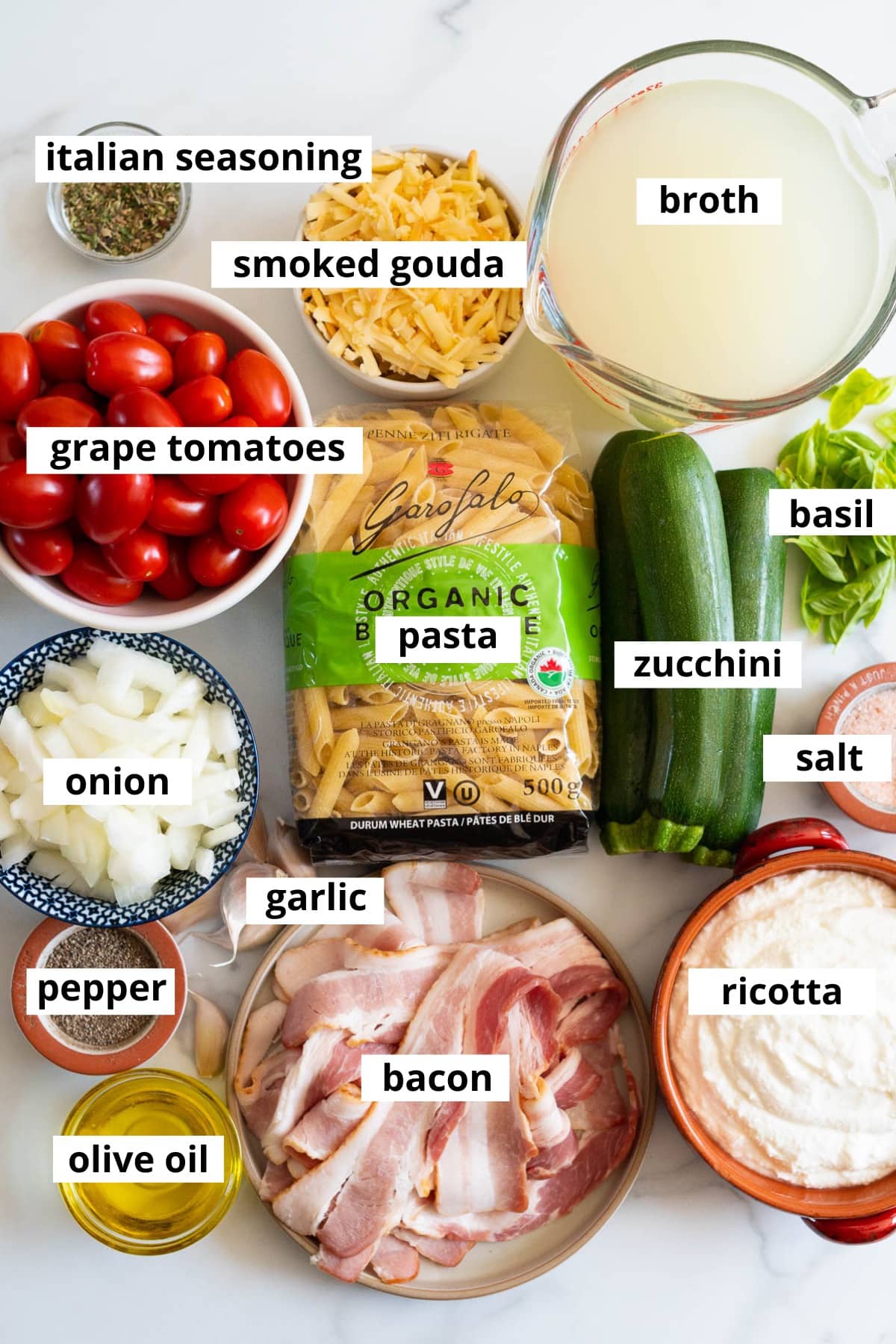 Pasta, grape tomatoes, smoked gouda cheese, Italian seasoning, broth, zucchini, basil, onion, garlic, salt, bacon, ricotta, pepper and olive oil.