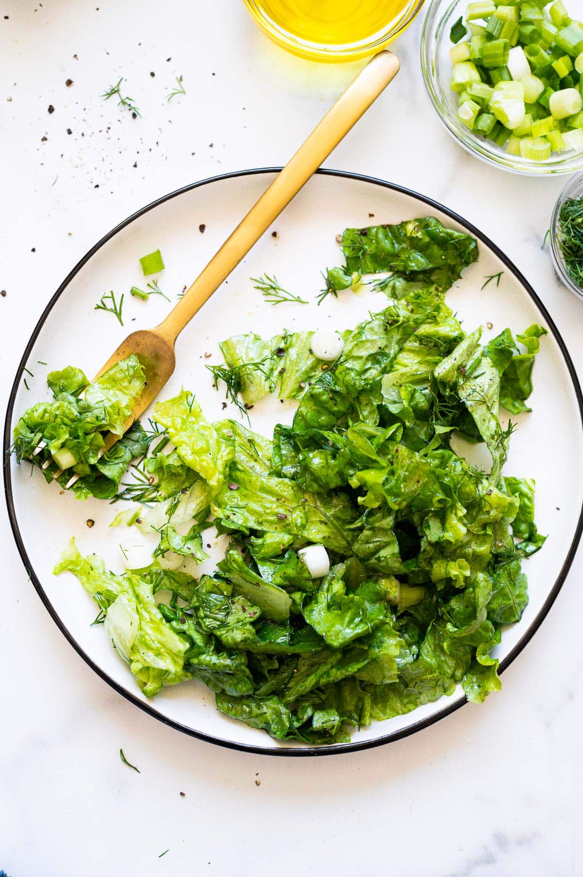 Butter lettuce salad served on a plate with a fork.