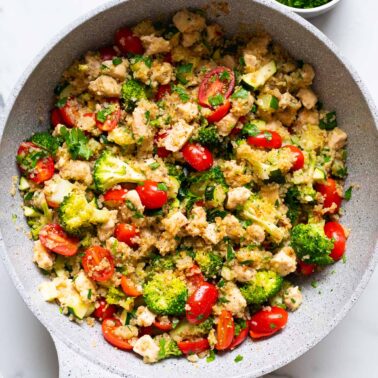 Chicken quinoa skillet with zucchini, broccoli and grape tomatoes.