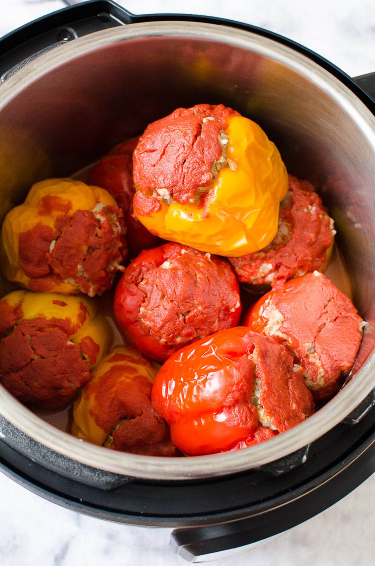 Cooked stuffed peppers topped with tomato sauce in Instant Pot.