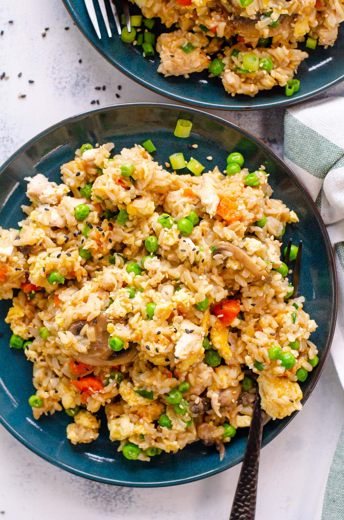 Instant pot chicken fried rice with mushrooms, peas, carrots and garnished with sesame seeds  plate.