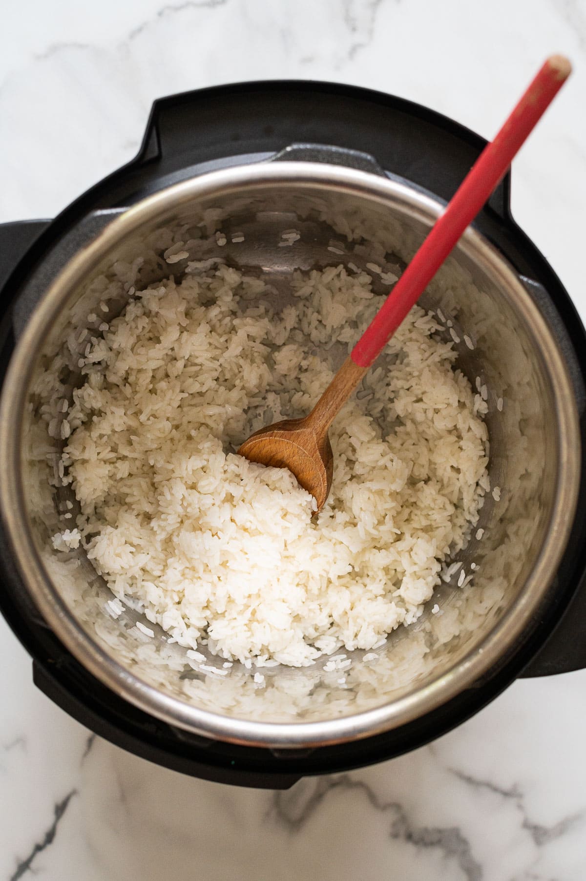 Instant Pot long grain white rice with wooden spoon in a pot.