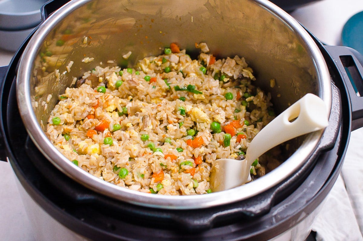 Chicken fried rice in Instant Pot with plastic serving spoon.