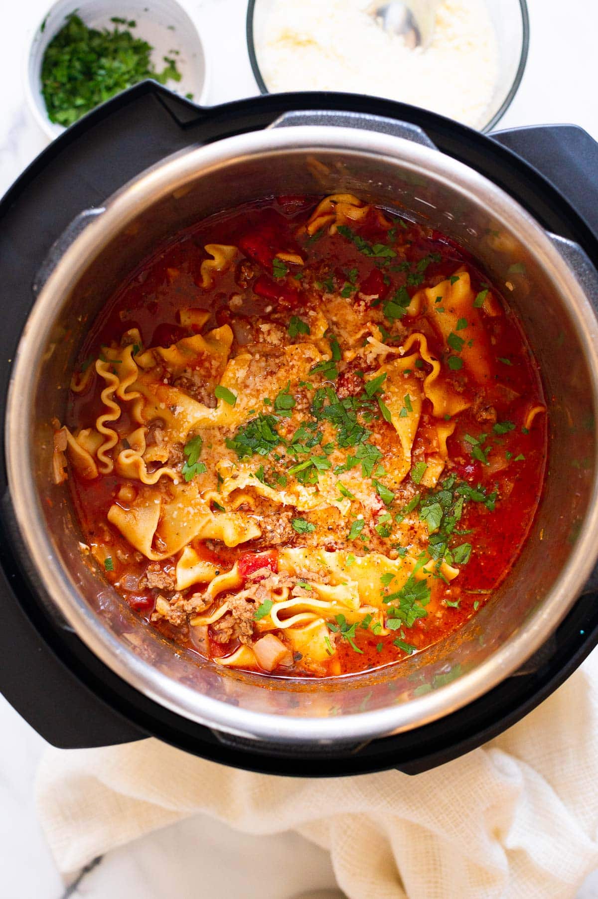 Lasagna soup in instant pot garnished with Parmesan cheese and parsley.