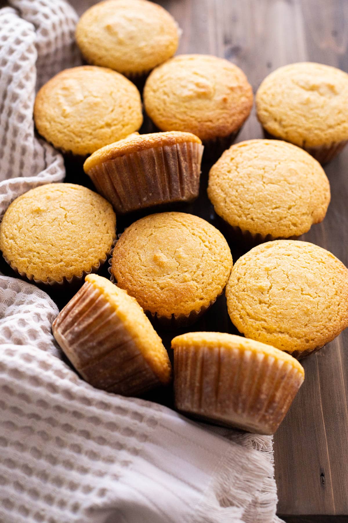 Side view of cornbread muffins on a wooden board.
