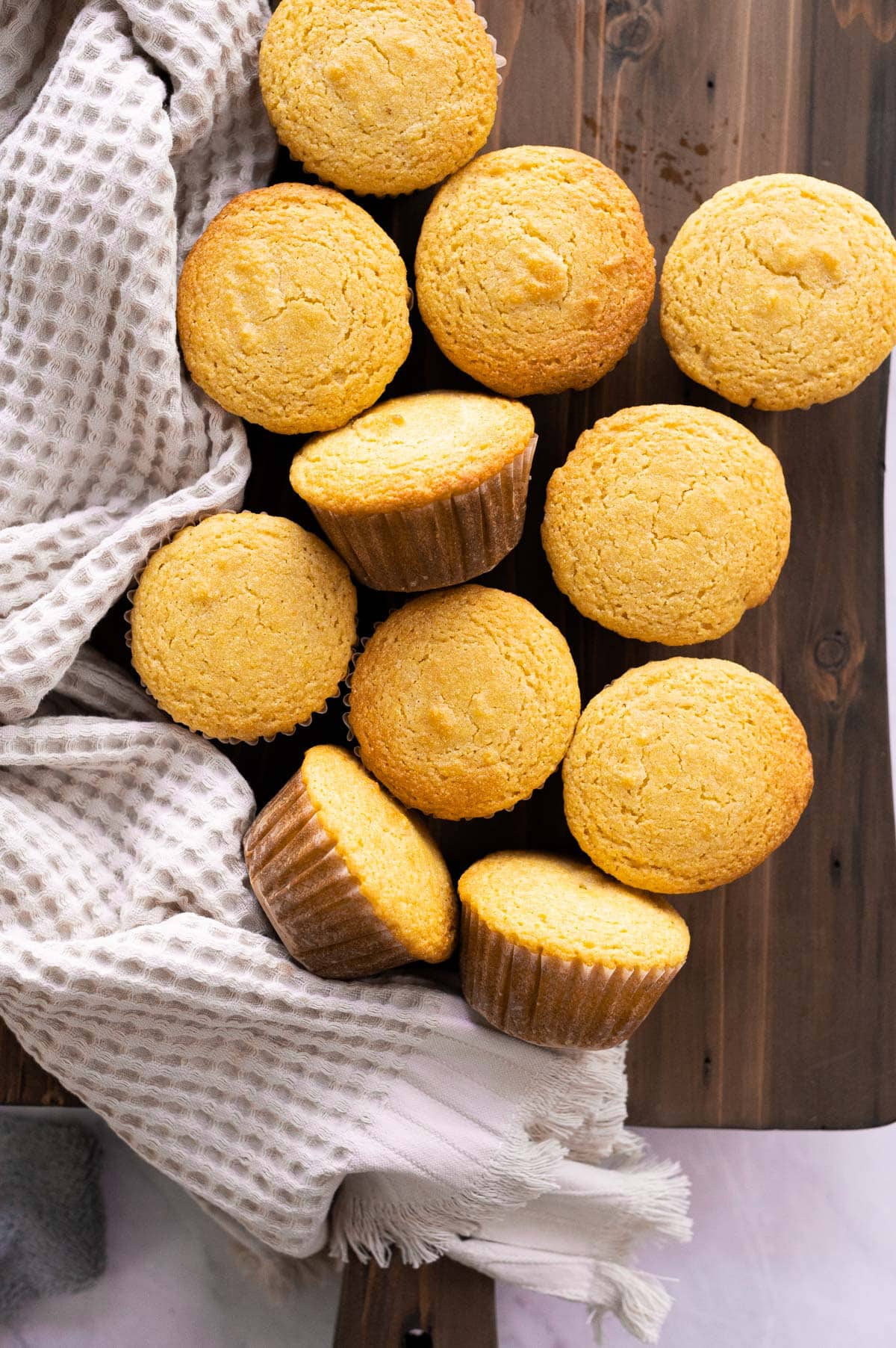 Healthy cornbread muffins on a wooden board and with linen towel.