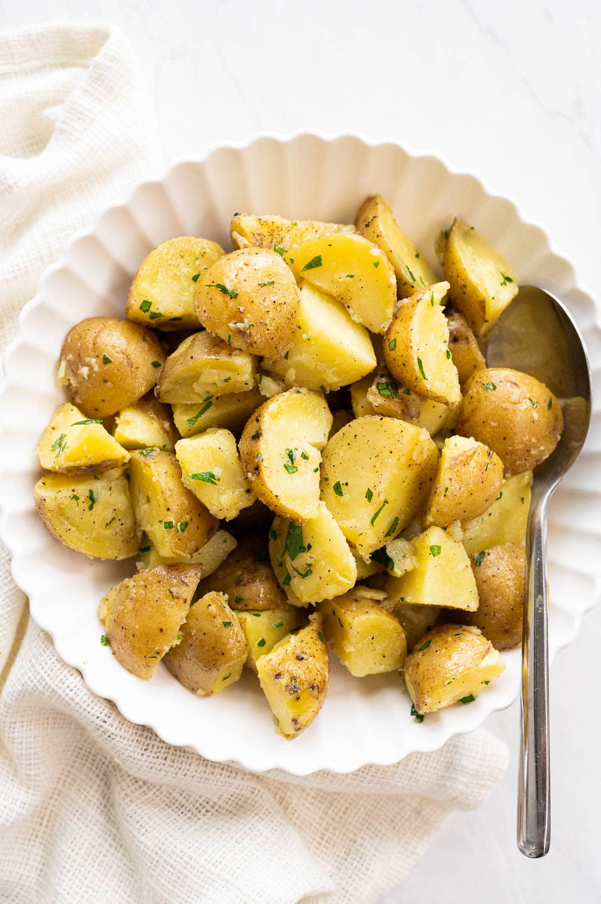 Instant Pot potatoes with fresh herbs served in a bowl with a spoon.