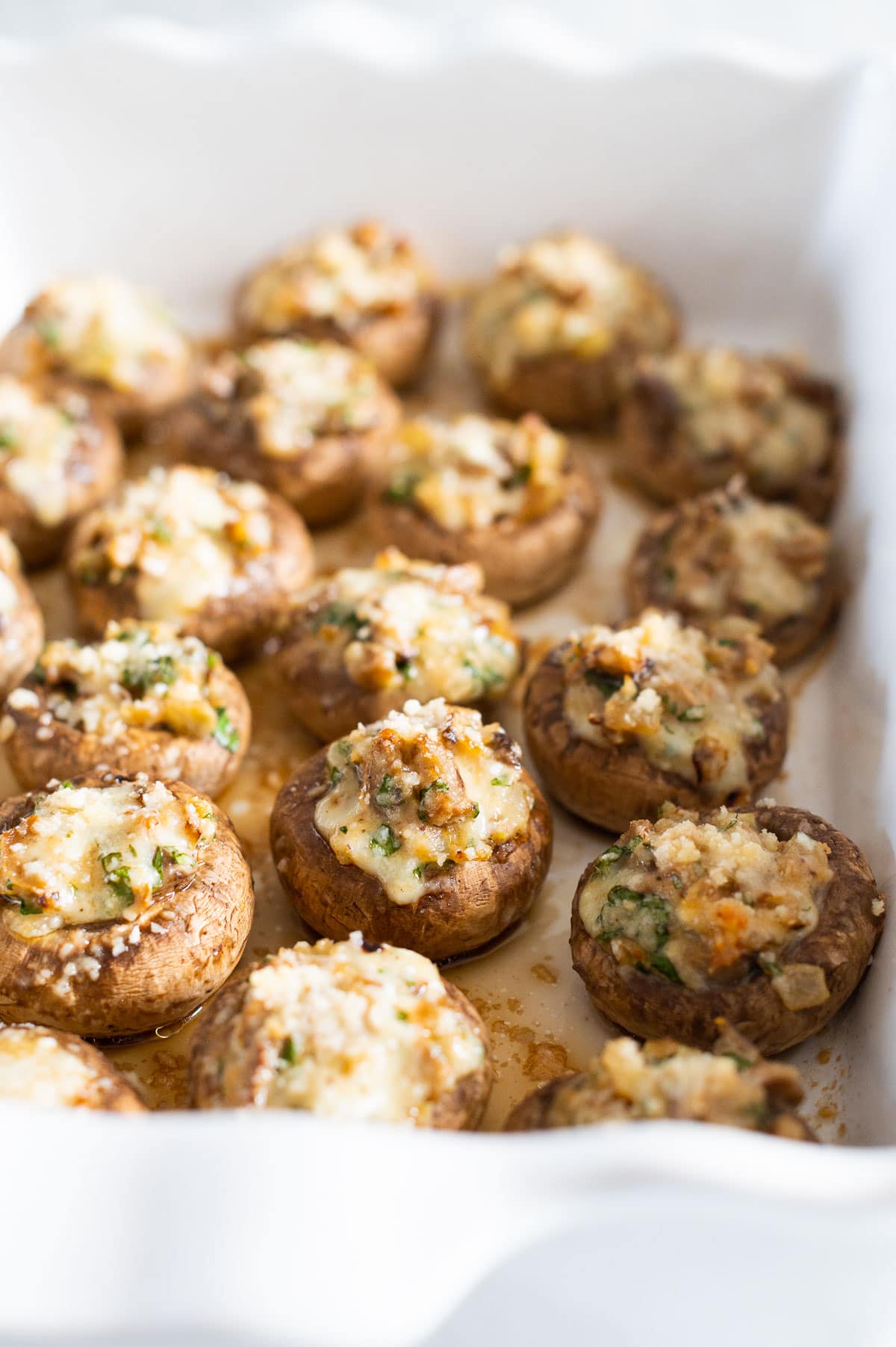 Stuffed mushroom caps in a baking dish.