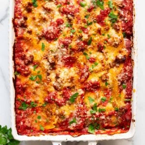 Baked cottage cheese lasagna garnished with parsley in a baking dish.