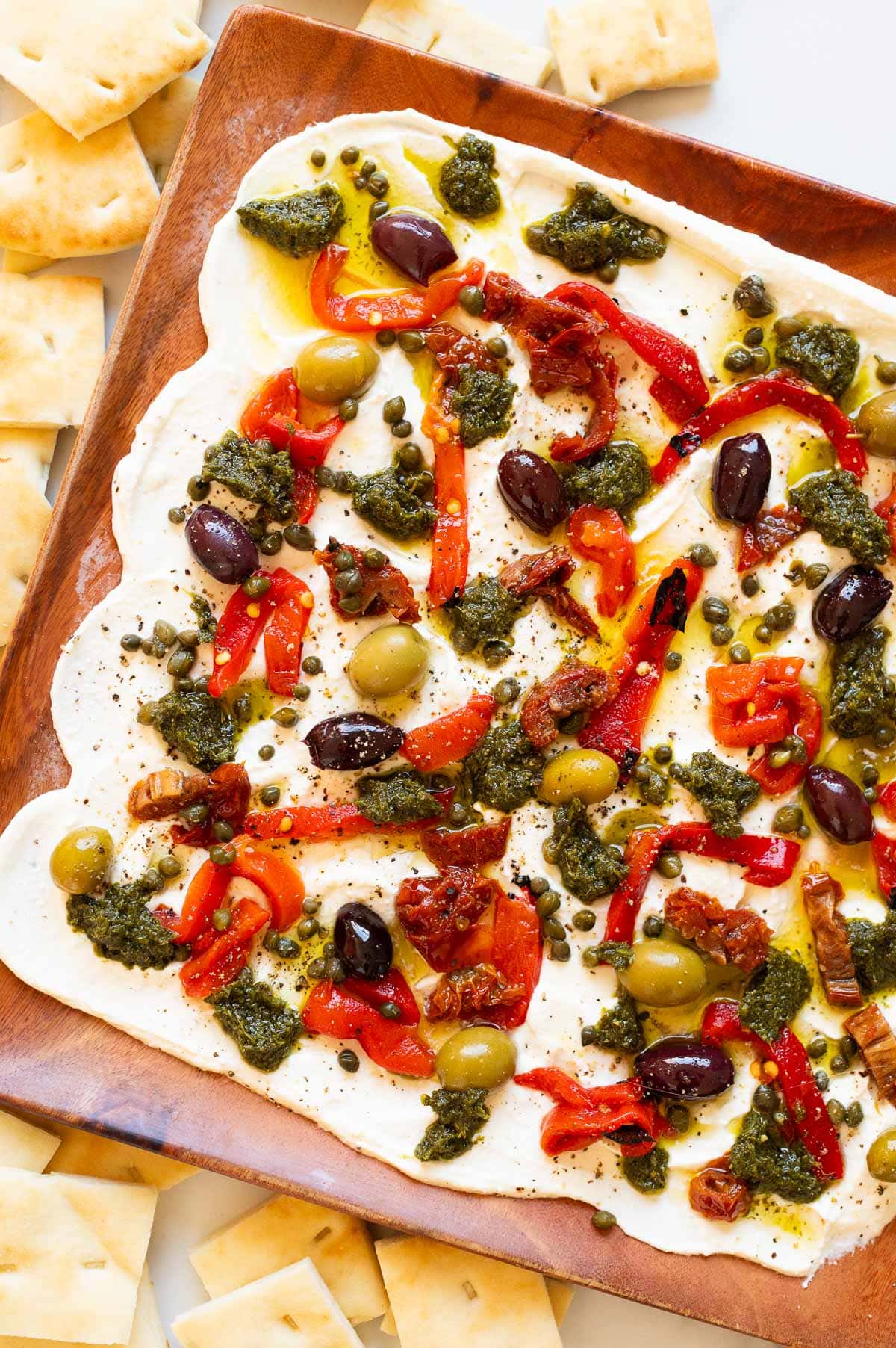 Whipped feta board with olived, capers and sun dried tomatoes served with pita bread.