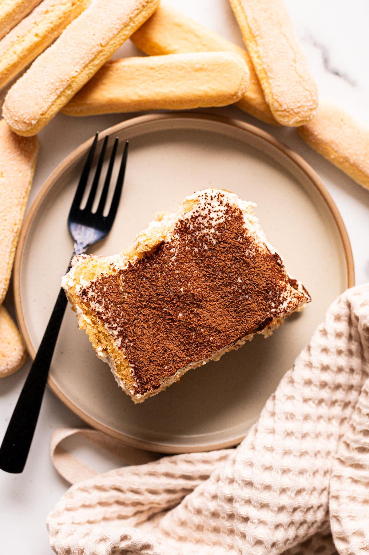 Cottage cheese tiramisu served on a plate with a fork.