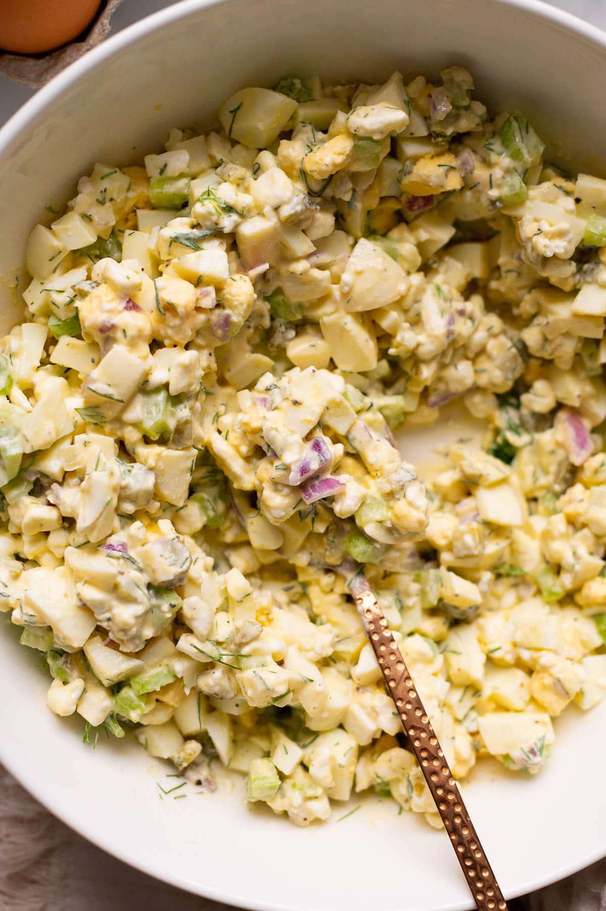 Cottage cheese egg salad with a spoon in a bowl.