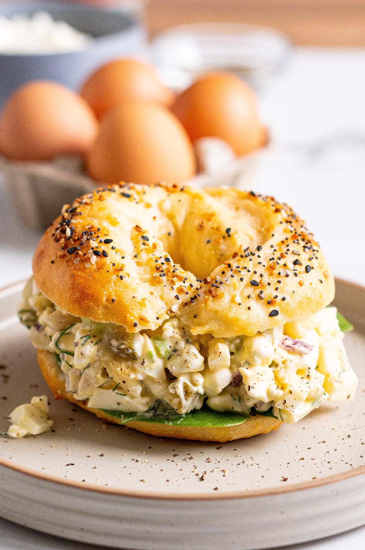 Cottage cheese egg salad served on a bagel with spinach.