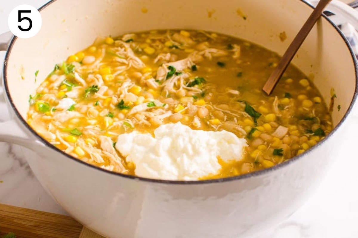 Pot with white chicken chili, yogurt and soup ladle in it.