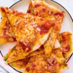 Greek yogurt pizza crust with marinara and cheese slices on a plate.