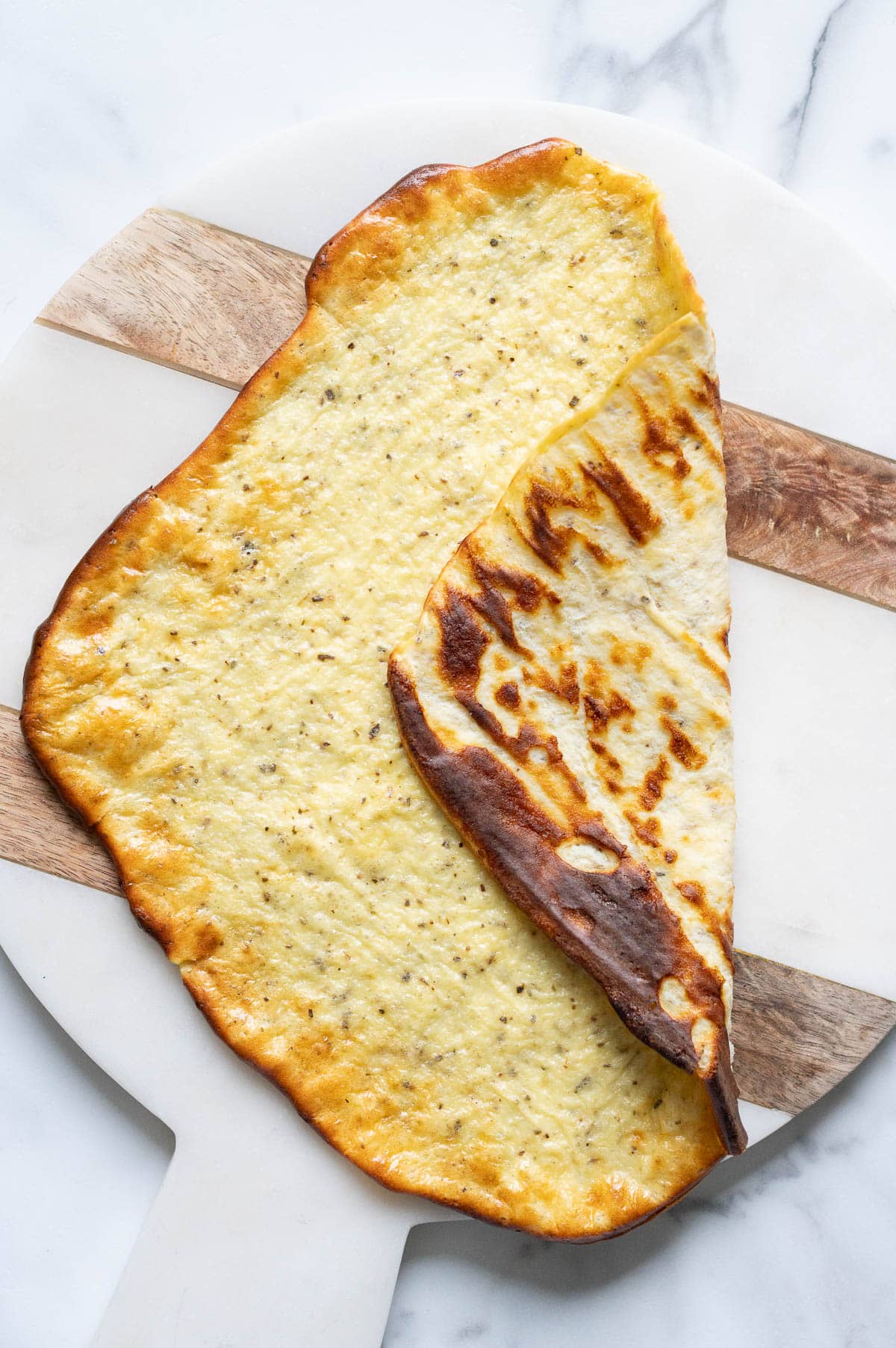 Cottage cheese flatbread folded in half on a platter.