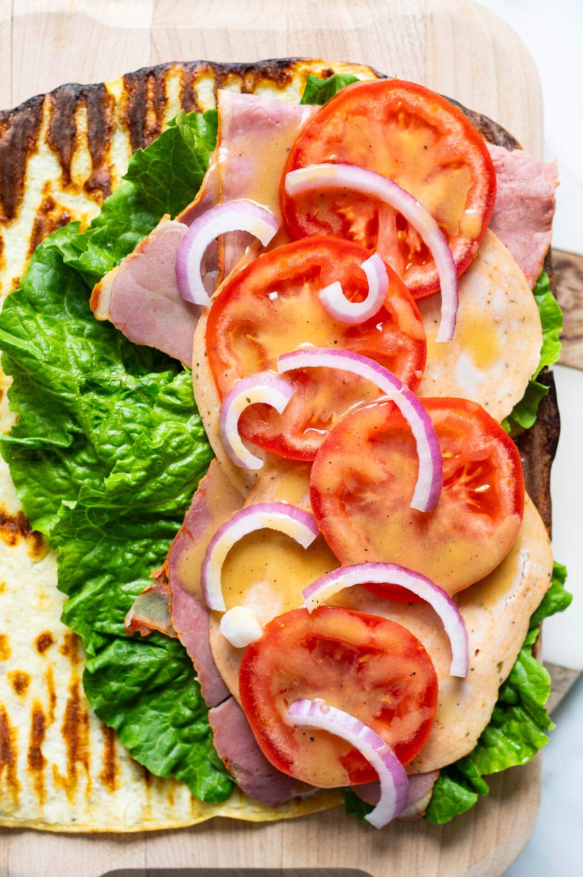 Lettuce, deli meat, tomatoes, red onion and honey mustard on cottage cheese flatbread.