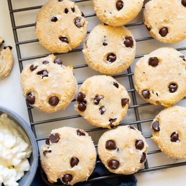 Cottage cheese cookies when a cooling rack. Cottage cheese and chocolate chips in bowls.