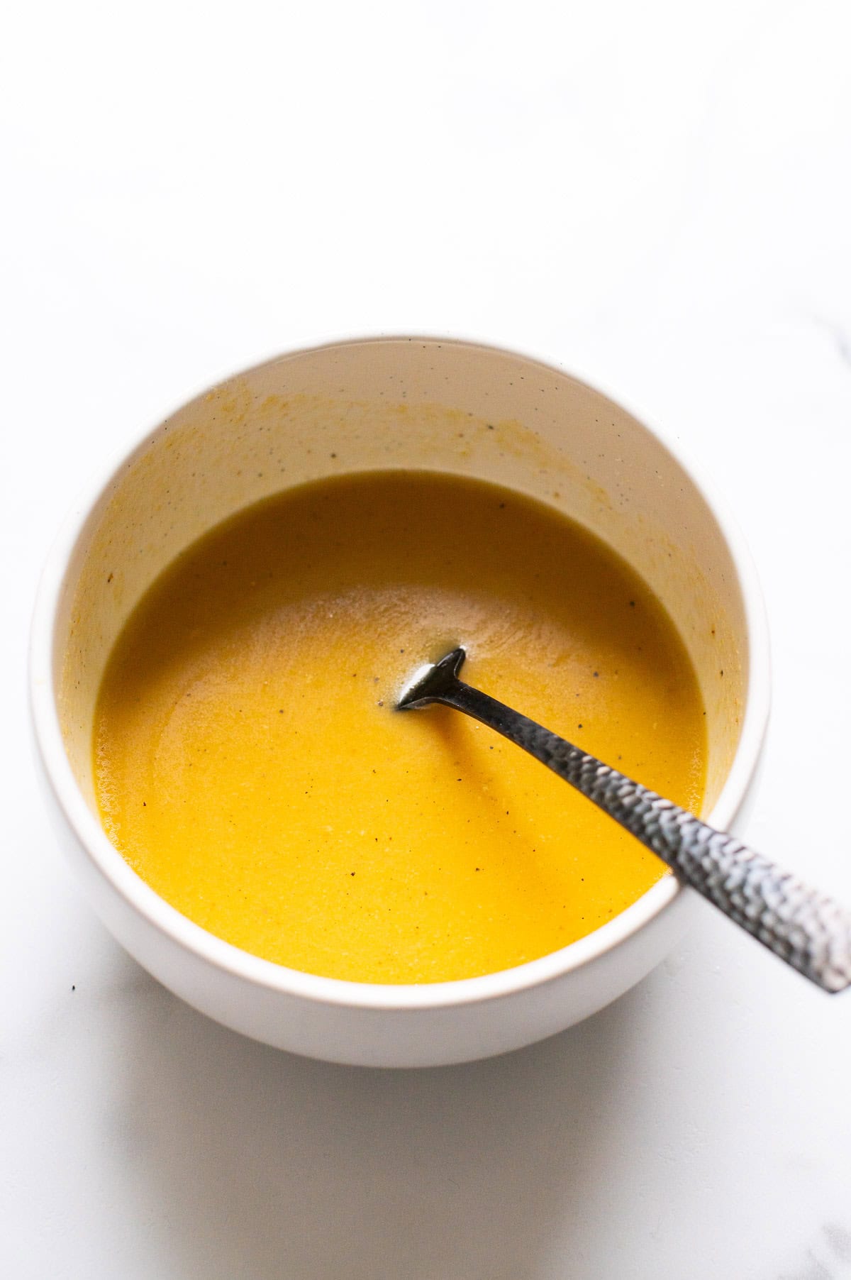 Healthy honey mustard dressing in a bowl with a spoon.