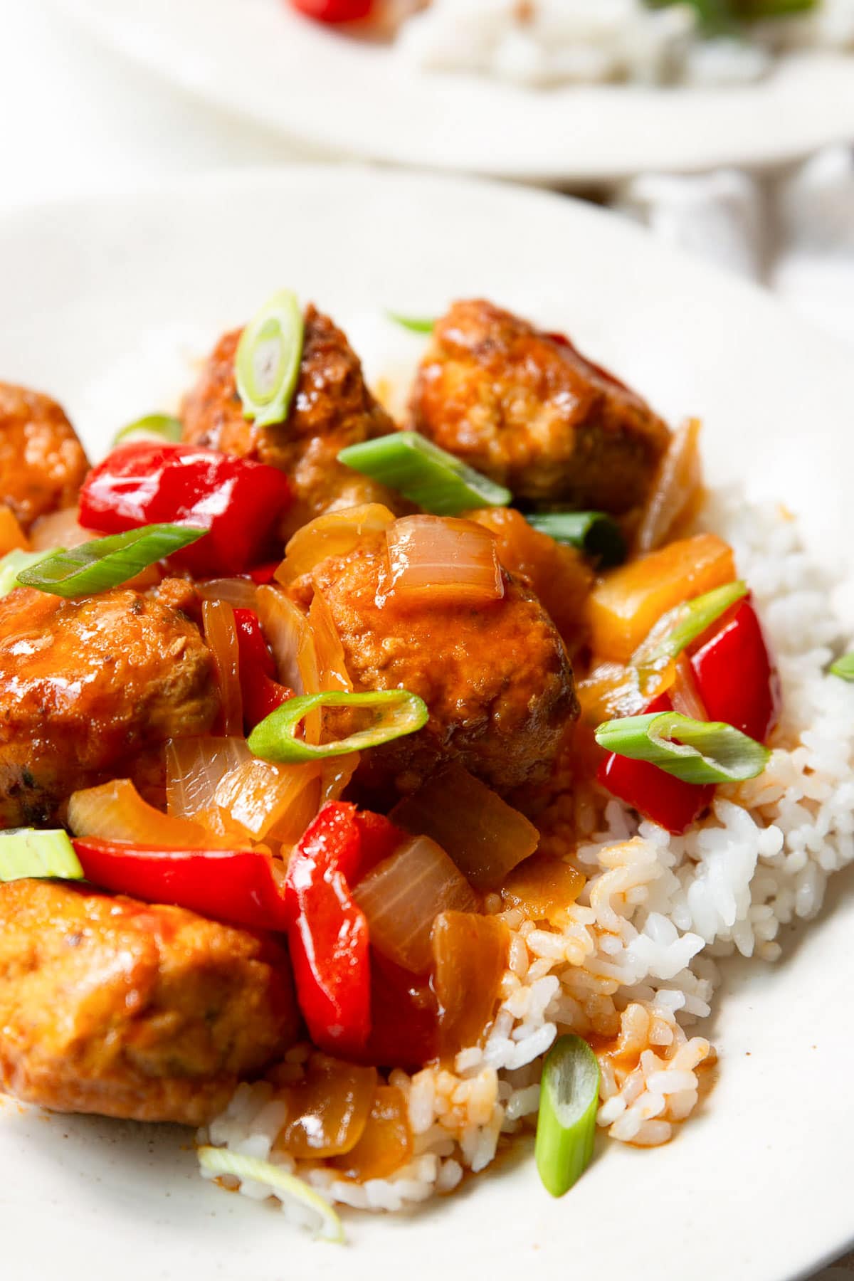 Close up of meatballs dish served over white rice.