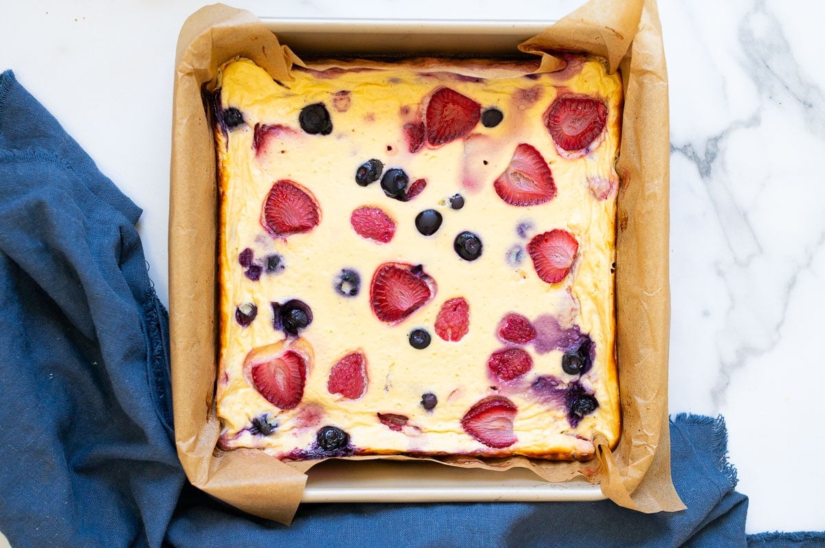 Baked Greek yogurt in a parchment line square baking dish.